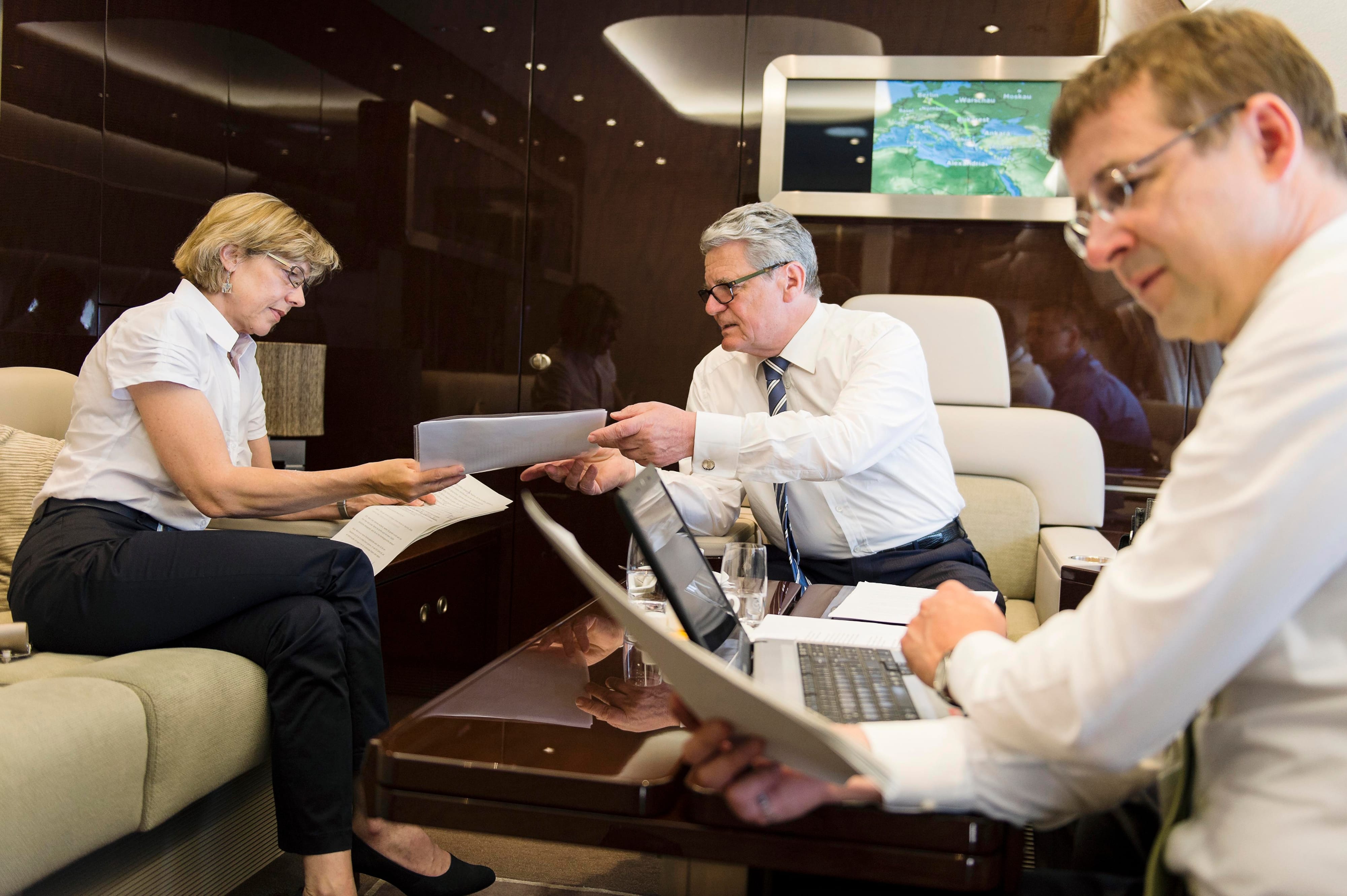 Bundespräsident Joachim Gauck geht mit Daniela Schadt und seinem Staatssekretär David Gill an Bord des Regierungsairbusses Redemanuskripte für seinen Staatsbesuch in Israel durch