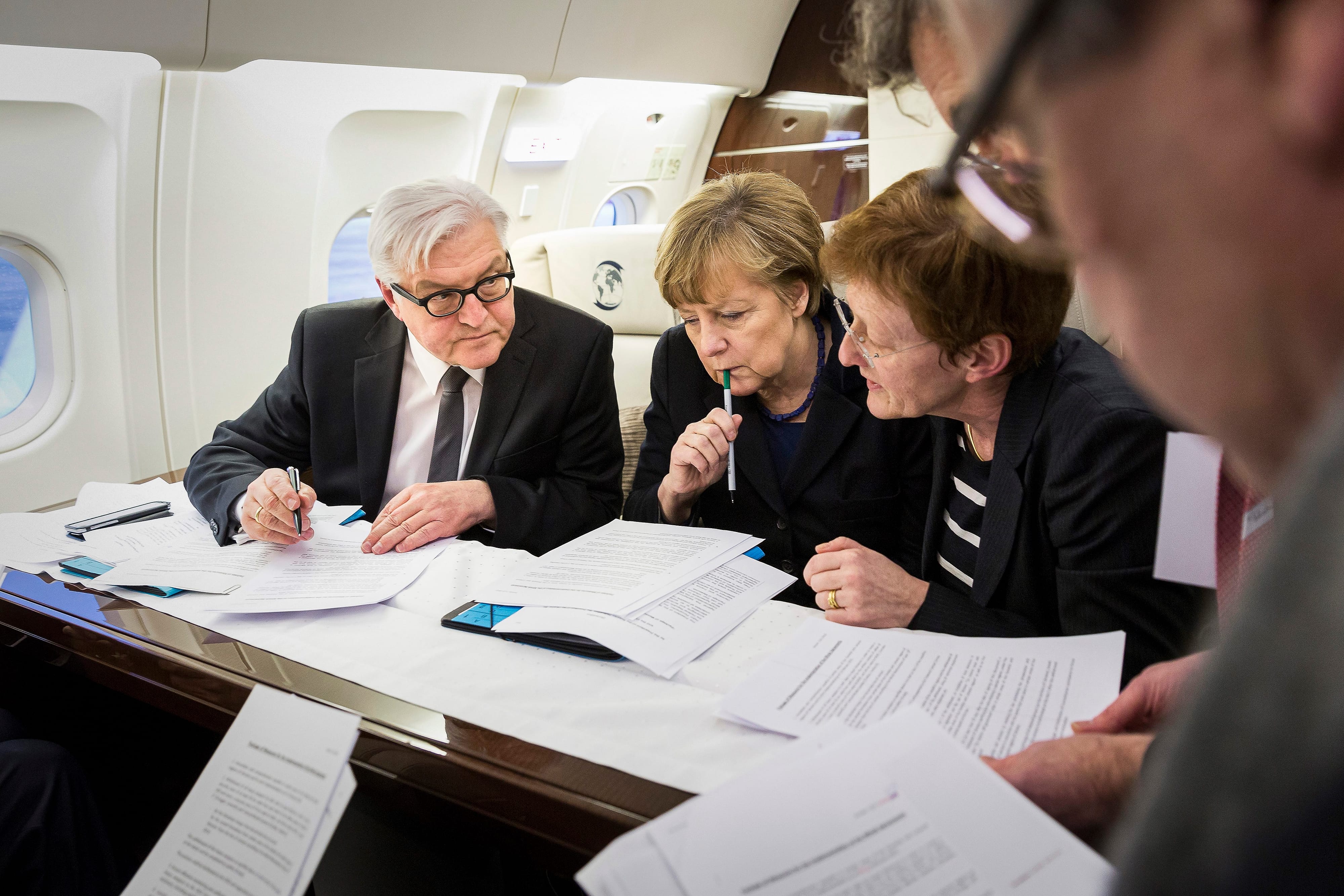 Bundeskanzlerin Angela Merkel und Bundesaußenminister Frank Walter Steinmeier gehen an Bord des Regierungsflugzeugs vor einem Treffen mit den russischen, ukrainischen und französischen Präsidenten in Minsk Unterlagen für Friedensgespräche zum Ukrainekonflikt durch